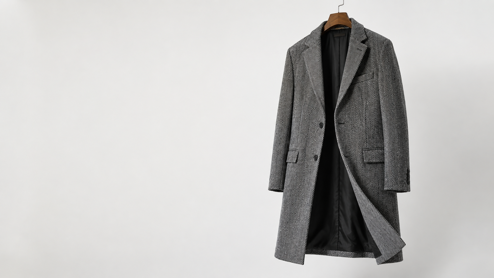 Grey herringbone overcoat on a hanger
